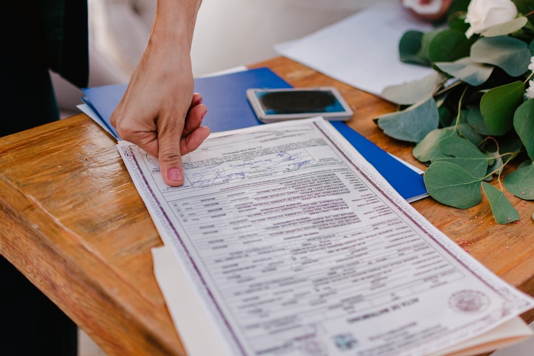 Pessoa Apontando Para Uma Certidao De Casamento Em Uma Mesa De Madeira uNMCWU0zjso